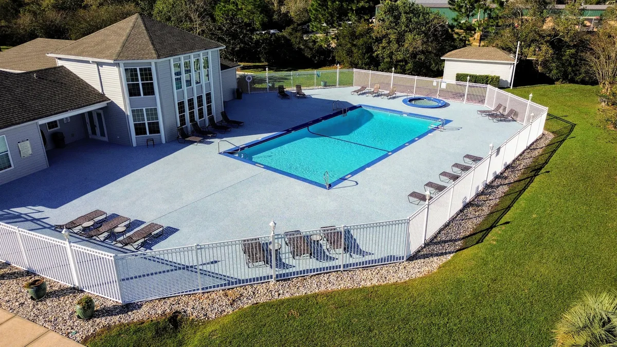 A sparkling swimming pool and inviting hot tub are surrounded by lounge chairs and a secure fenced area, offering a relaxing setting for families to cool off, swim, or unwind together after busy days of exploration.